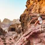 Petra - woman traveler tourist sitting on viewpoint in Petra.